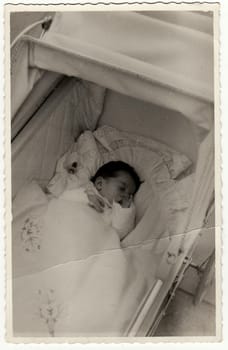 HODONIN, THE CZECHOSLOVAK REPUBLIC - CIRCA 1940: A vintage photo shows a small baby girl in a pram (baby carriage).