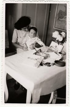 HODONIN, THE CZECHOSLOVAK REPUBLIC - CIRCA 194: A vintage photo shows small toddler girl and her first birthday. Toddler shows cute face.