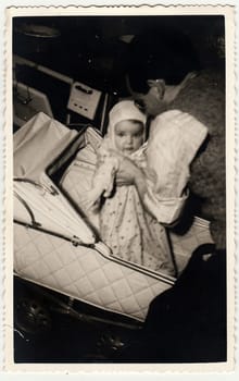 HODONIN, THE CZECHOSLOVAK REPUBLIC - CIRCA 1941: A vintage photo shows small baby girl, her father and pram (baby carriage).