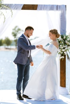 wedding ceremony on a high pier near the river with invited guests