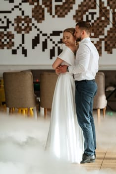 the first dance of the bride and groom inside a restaurant with heavy smoke