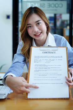 Portrait of a beautiful bank young woman sign credit department of signing approval for a home loan.