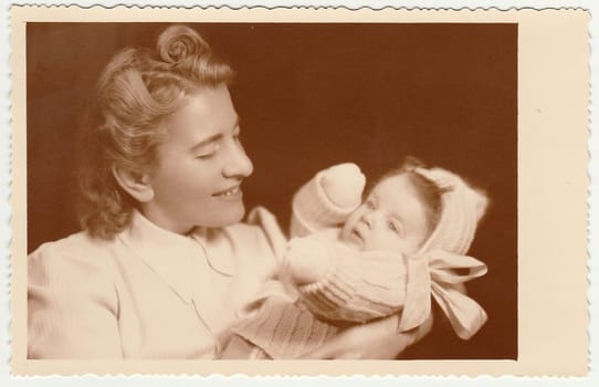 THE CZECHOSLOVAK REPUBLIC - CIRCA 1940: Vintage photo shows woman with cute baby. Photo has sepia tint.