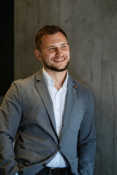 portrait of smiling groom with beard in blue color suit