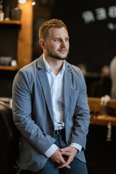 portrait of a young guy groom at the training camp in the barbershop with shaving and styling