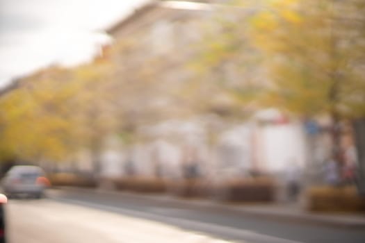 Autumn season bokeh background. Abstract city blur along the road with cars