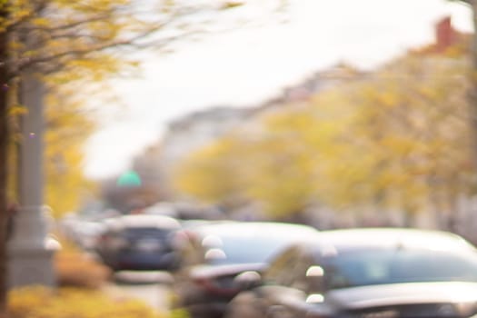 Autumn season bokeh background. Abstract city blur along the road with cars