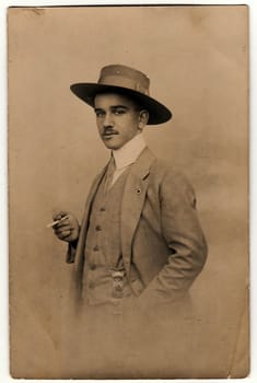 OLOMOUC, THE CZECHOSLOVAK REPUBLIC - CIRCA 1920s: Vintage photo shows dandy man with cigarette and hat. Antique black white photo.