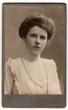 WIEN, AUSTRIA-HUNGARY - CIRCA 1915: Vintage cabinet card shows woman with Victorian and Edwardian hair style. Antique black white photo.