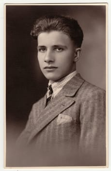HODONIN, THE CZECHOSLOVAK REPUBLIC - MARCH 21, 1931: A vintage studio photo shows young man wears posh jacket. Antique black white photo.