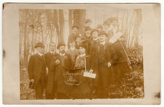 PARIS, FRANCE - CIRCA 1900s: Vintage photo shows group of people - Czech patriots in France. At the forefront man and woman hold standard with text in Czech: Equality Pariz.