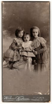 BERLIN, GERMANY- CIRCA 1905: A vintage cabinet card shows cute children girls . Antique black white photo.