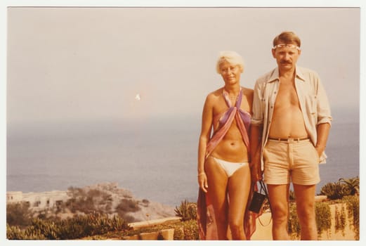 IBIZA, SPAIN - 1981: Vintage photo shows couple on summer vacation at sea resort.