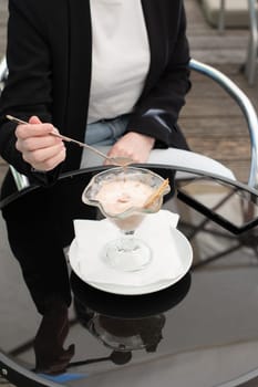 faceless photo business woman thoughtfully notes melted ice cream in a bowl, she enjoys a break at work, High quality photo