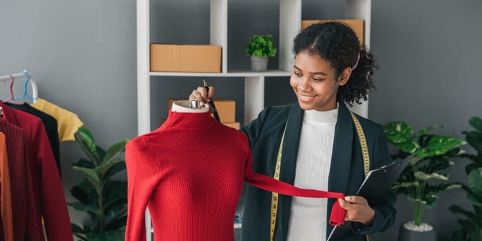 portrait smile black woman working on clothes in tailoring atelier. Attractive beautiful young female fashion designer smile after success in make new handmade suit in workshop...