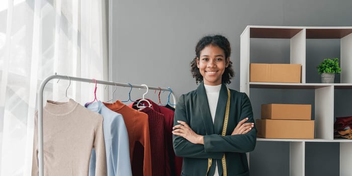 portrait smile black woman working on clothes in tailoring atelier. Attractive beautiful young female fashion designer smile after success in make new handmade suit in workshop...