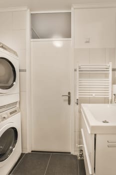 a laundry room with a washer and dryer in front of the washing machine on the wall is white