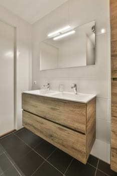 a bathroom with two sinks and a mirror on the wall behind it is an open door that leads to a walk - in shower