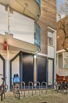 two bikes parked in front of a building with blue doors and railings on either side of the street,