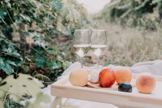 Picnic and wine tasting at sunset in the hills of Italy, Tuscany. Vineyards and open nature in the summer. Romantic dinner, fruit and wine.