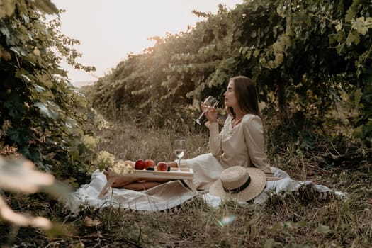 Picnic and wine tasting at sunset in the hills of Italy, Tuscany. Vineyards and open nature in the summer. Romantic dinner, fruit and wine.