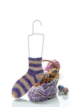 Colored threads, knitting needles and other items for hand knitting, isolated on a white background.