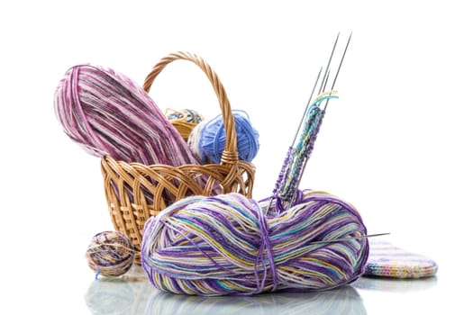 Colored threads, knitting needles and other items for hand knitting, isolated on a white background.