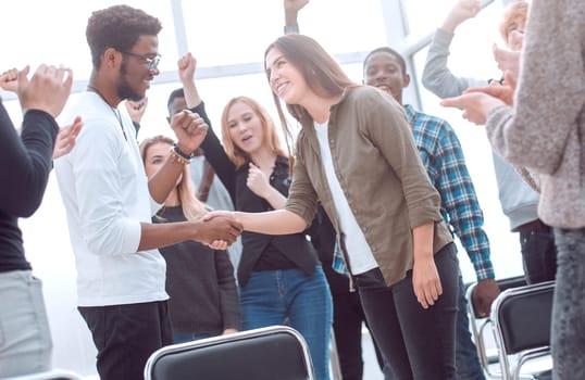 group of happy young people congratulating their colleague . concept of success