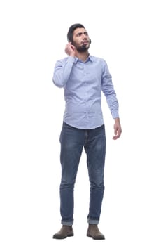 in full growth. young man in a headset looking at a white screen. isolated on a white background.