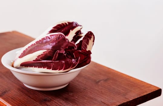 Radicchio, red  leaves chicory, italian chicory in white bowl , common use in Italian cuisine