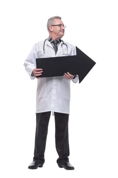 Mature doctor holding a black arrow pointing right isolated on white background
