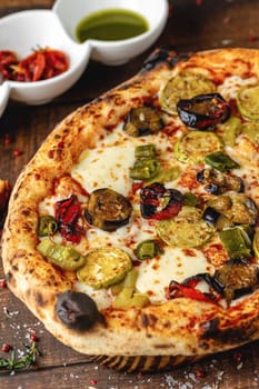 Vegetarian pizza with eggplant, zucchini and mushrooms on dark stone table