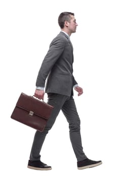 in full growth. a business man with a leather briefcase striding forward. isolated on a white background.