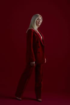 Portrait of a blonde woman in red dress on a red background