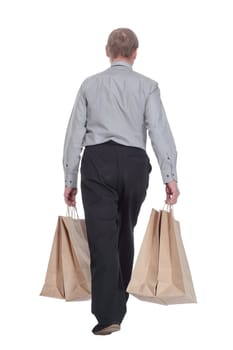 rear view. casual man with shopping bags strides away. isolated on a white background.