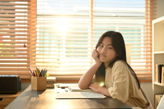 Portrait of bored asian female student doing homework at home. Education and learning concept.
