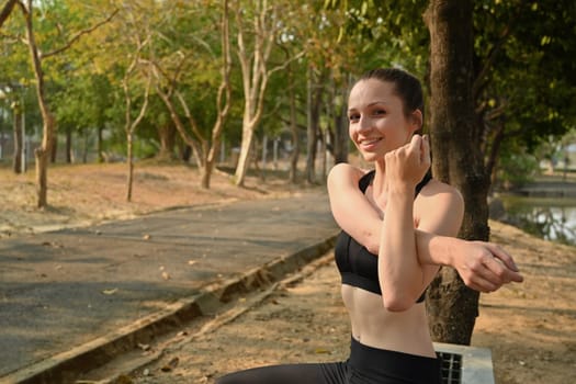 Motivated sporty woman warming up before morning workout. Fitness, sport and healthy lifestyle concept.