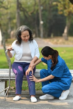 Female caregiver assisting, taking care of elderly woman during walking in rehabilitation center. Assistance, rehabilitation concept.