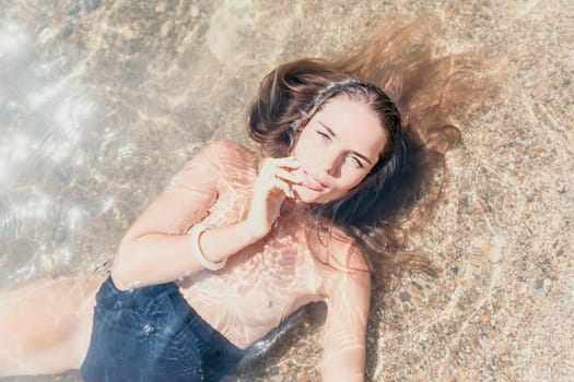 Woman travel sea. Young Happy woman in a long red dress posing on a beach near the sea on background of volcanic rocks, like in Iceland, sharing travel adventure journey