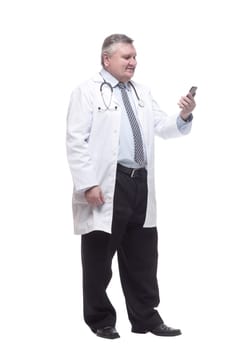 in full growth. smiling doctor with a smartphone. isolated on a white background.