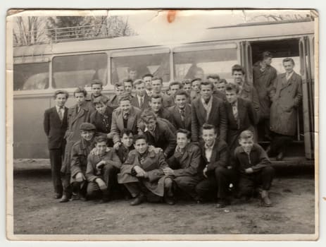 THE CZECHOSLOVAK SOCIALIST REPUBLIC - 1960s: Vintage photo shows young students pose in front of bus. Photo has error obtained during photo process.