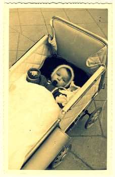 HODONIN, THE CZECHOSLOVAK REPUBLIC - CIRCA 1940: A vintage photo shows small baby girl in a pram (baby carriage).