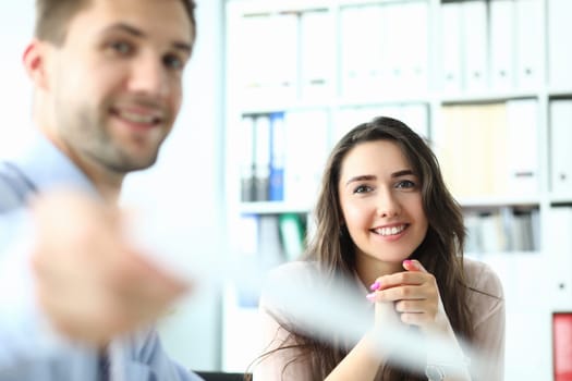 Portrait of successful entrepreneur in conference room holding paper document and smiling at camera. Business meeting and partnership concept