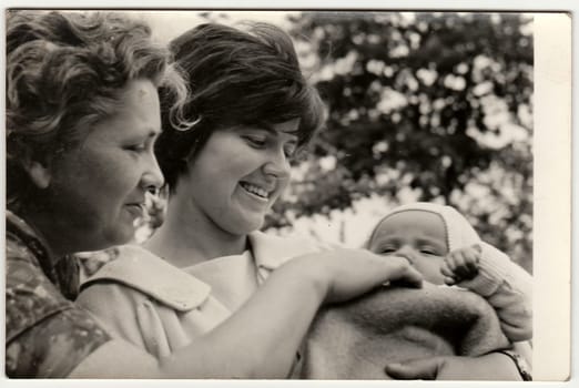 THE CZECHOSLOVAK SOCIALIST REPUBLIC - 1960s: Vintage photo shows young woman cradles baby and its grandmother.