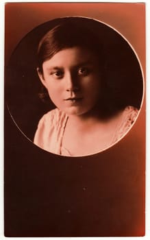 HODONIN, THE CZECHOSLOVAK REPUBLIC - DECEMBER 19, 1928: Vintage studio portrait shows young girl. Antique black white photo portrait has round shape with sepia tint.