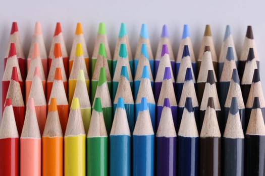 Set of multicolored pencils lying on white table in row. Creativity variou of possibilities and play of imagination and fantasy make the world bright and impressive