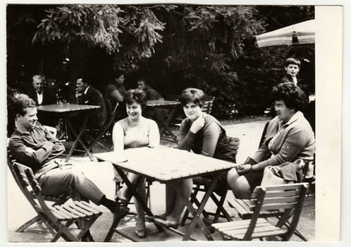 THE CZECHOSLOVAK SOCIALIST REPUBLIC - CIRCA 1960s: Vintage photo shows group of people sit at the garden restaurant.