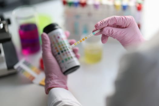 Chemist scientist holding ph test in hands closeup. Analysis in laboratory concept