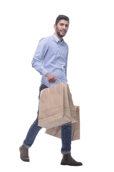 in full growth. happy man with shopping bags confidently striding forward. isolated on a white background.