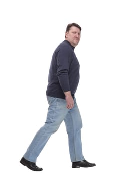 in full growth. Mature man in jeans striding forward.isolated on a white background.